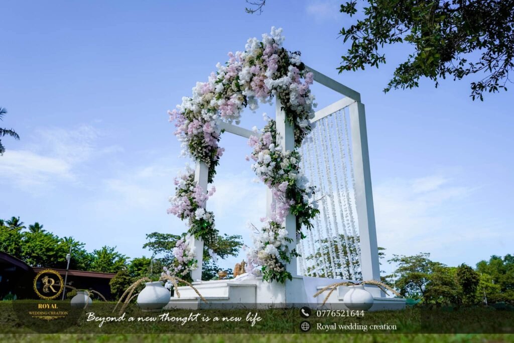 Clear outdoor wedding arch with white and lilac flowers