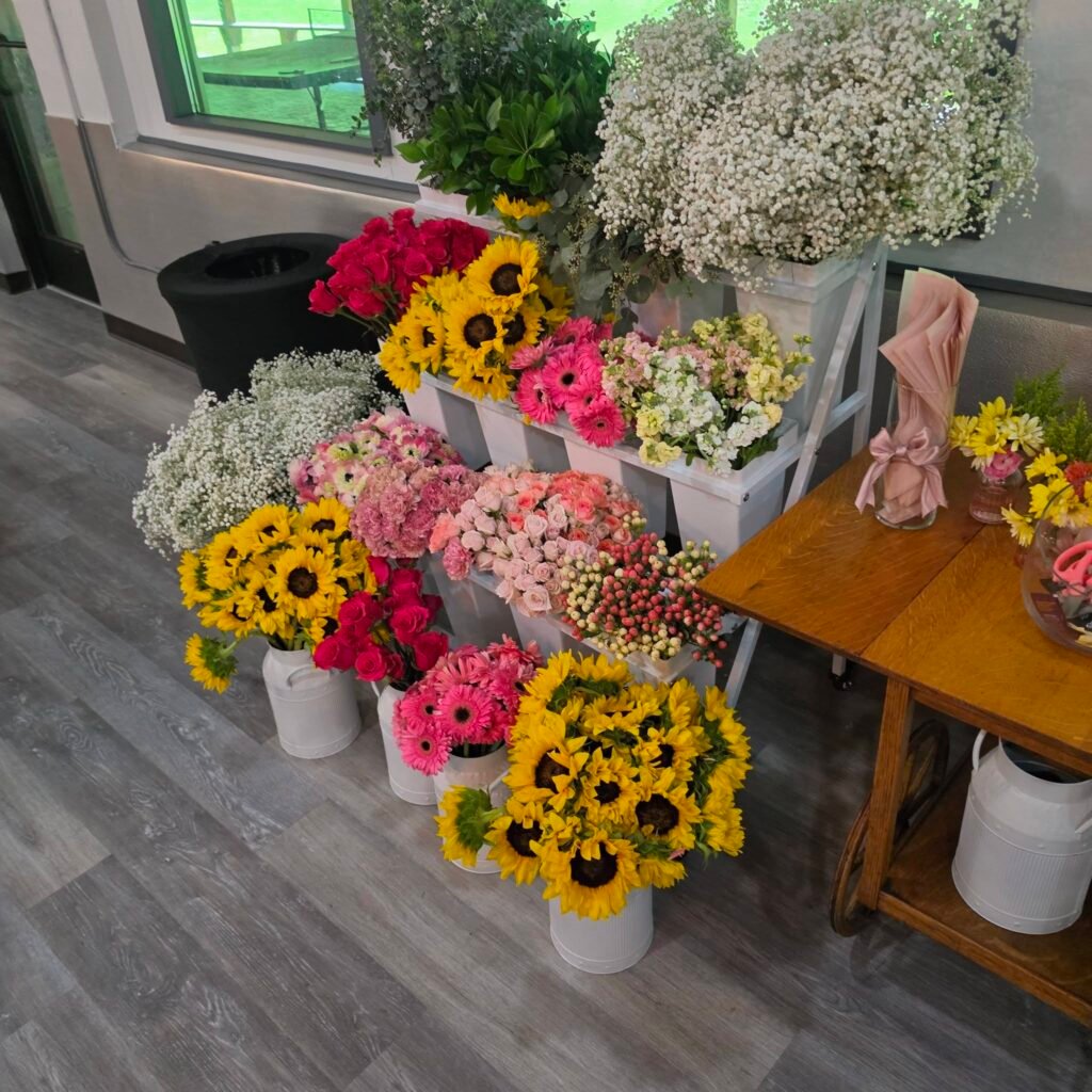 Flower bar with buckets of sunflowers, roses and babys breath