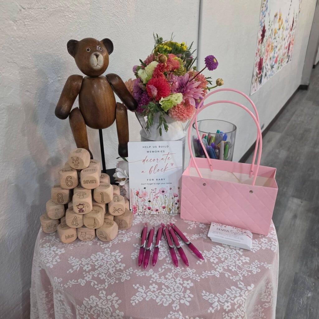 Wood teddy bear with block favors and a pink basket on a lace table