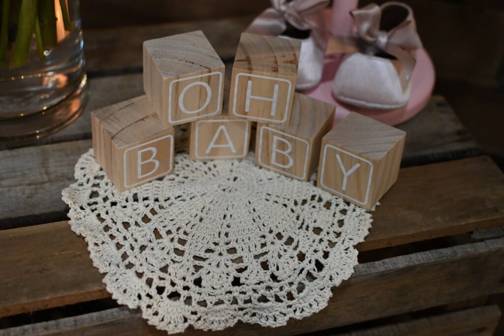 OH BABY wood blocks on a white crochet doily