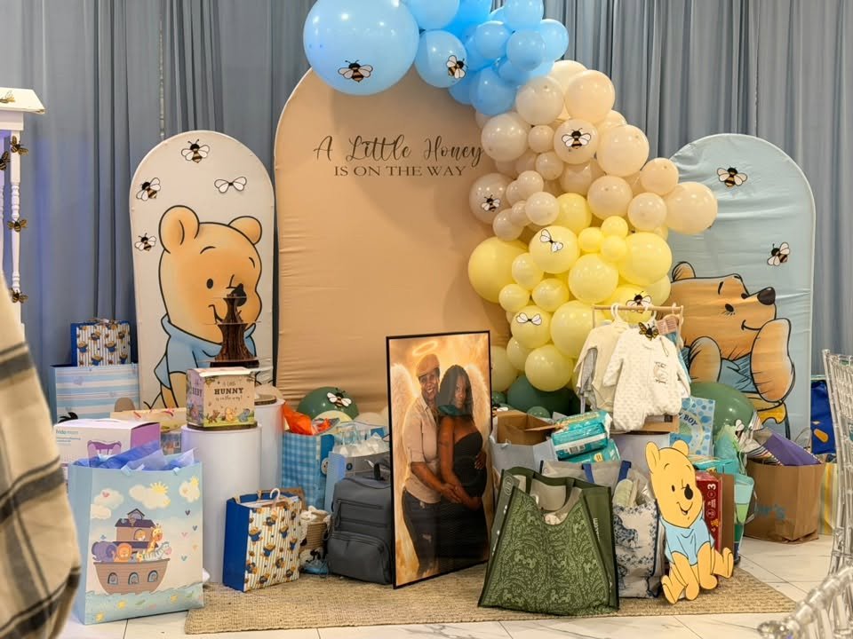 Pooh backdrop with a balloon arch and gifts
