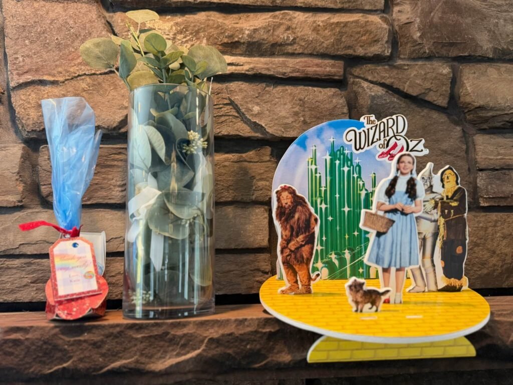 Table decor with an Oz scene cutout and a green vase
