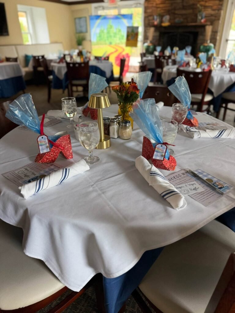 Round tables with ruby slippers and blue favors
