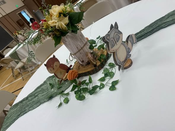 Woodland animal centerpiece with a fox, bunny and flowers on a sage runner