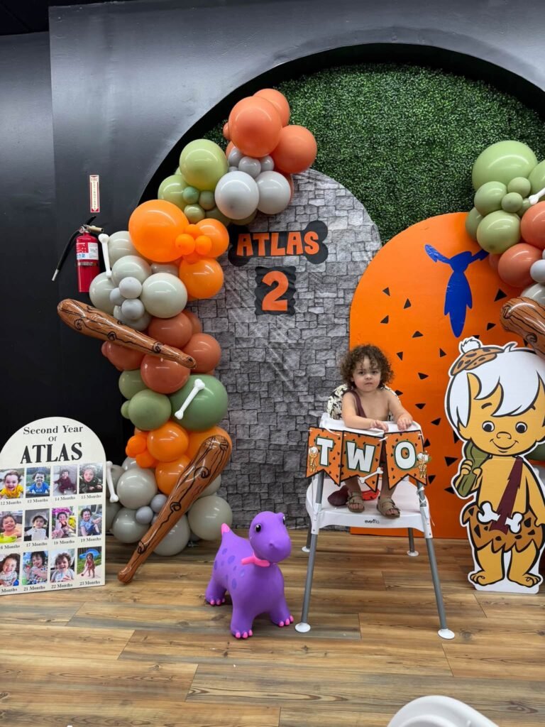 High chair with a TWO banner in front of the stone backdrop